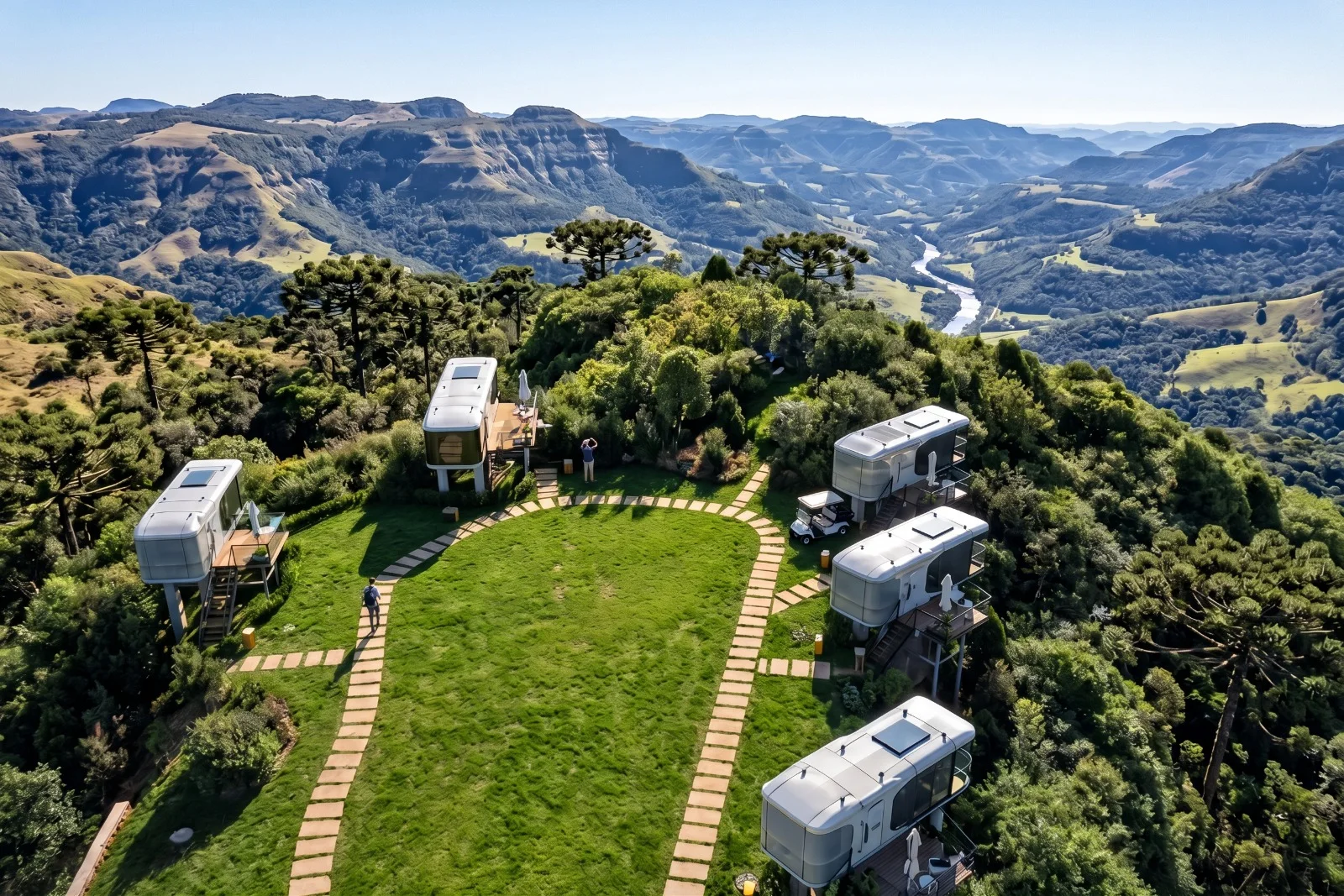 Conjunto de casas cápsula em uma área verde cercada por montanhas